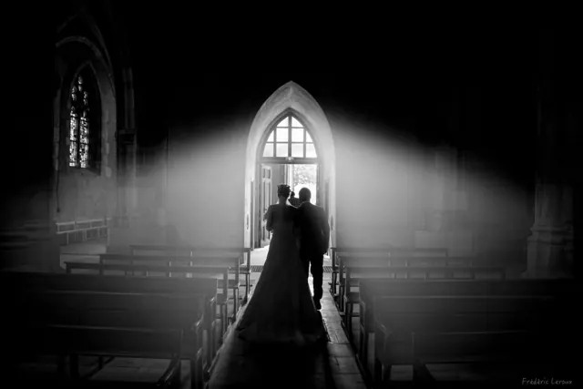 Mariés sortant de l’église dans un rai de lumière – photographe de mariage à Reims