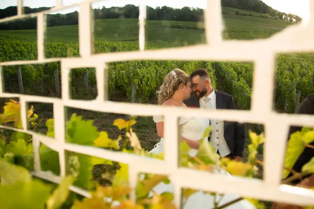 Mariés photographiés à travers un cadre, dans les vignes – Frédéric Leroux, photographe de mariage à Reims