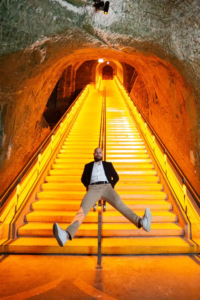 Le marié dans l'escalier lumineux des caves – Frédéric Leroux, photographe de mariage à Reims